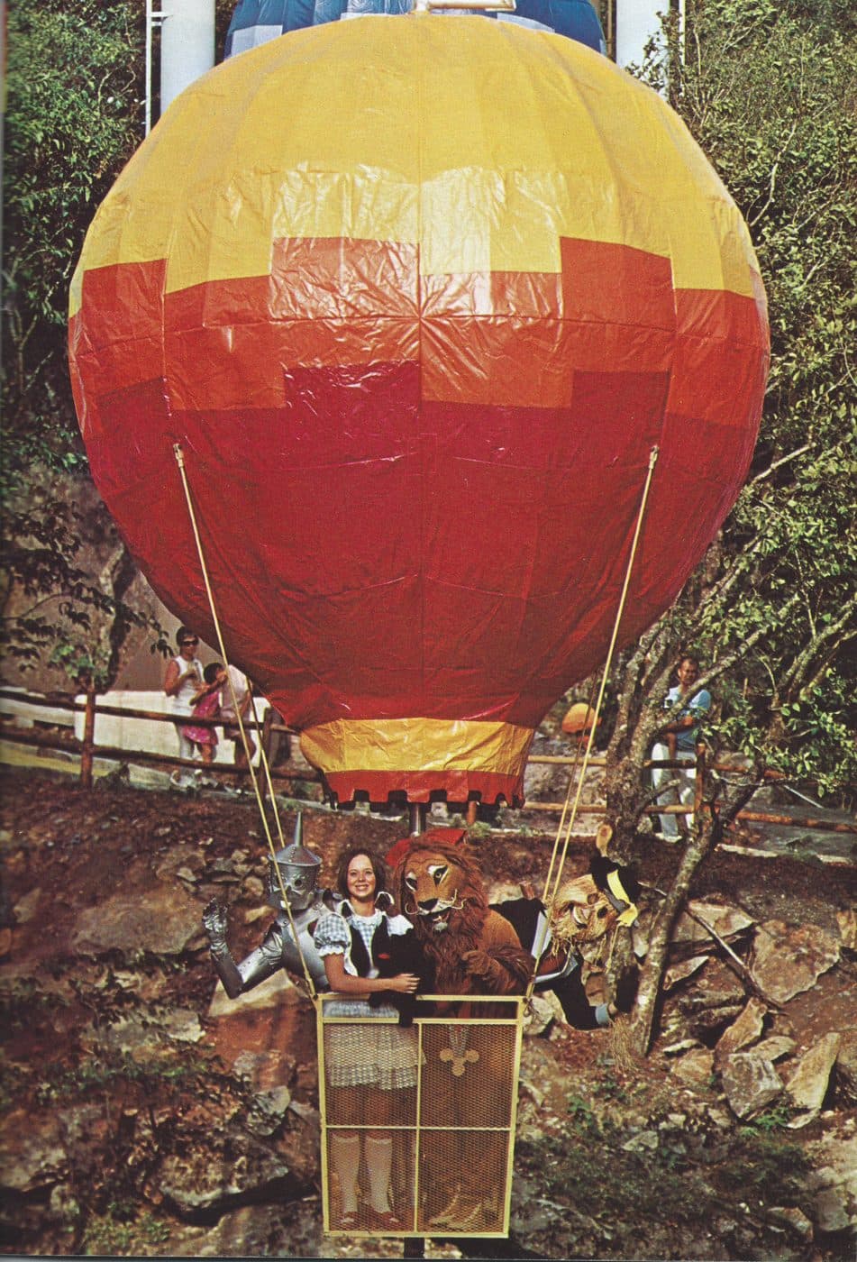 Vintage photograph of the iconic Land of Oz hot air balloon ride — a yellow and red balloon with the Wizard of Oz cast in the basket